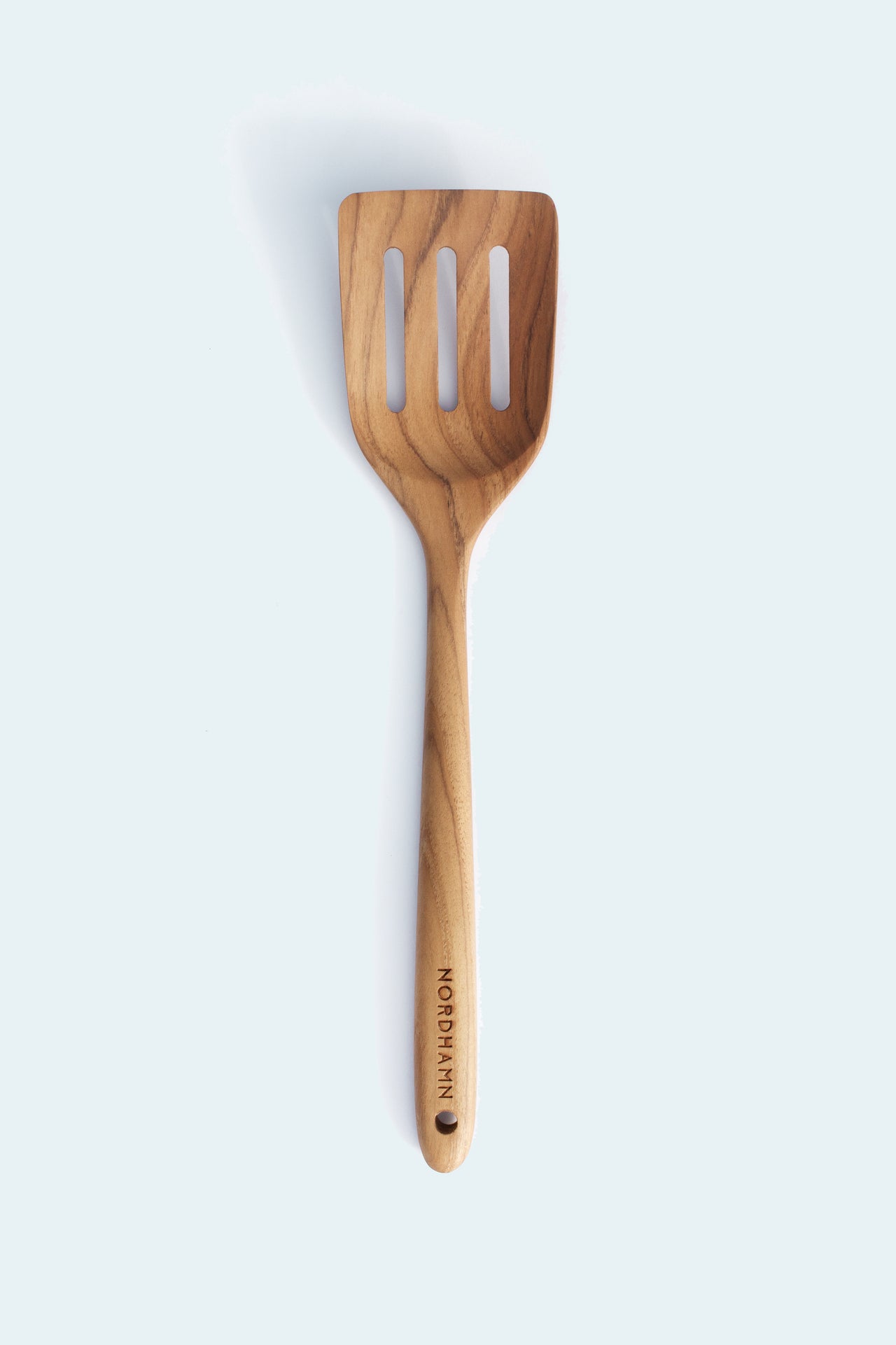 Perforerad stekspade, 34 cm, i teak mot ljus bakgrund